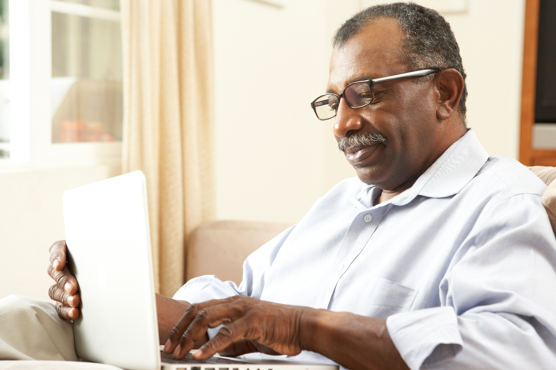 A Seasoned Adult using a laptop at home.